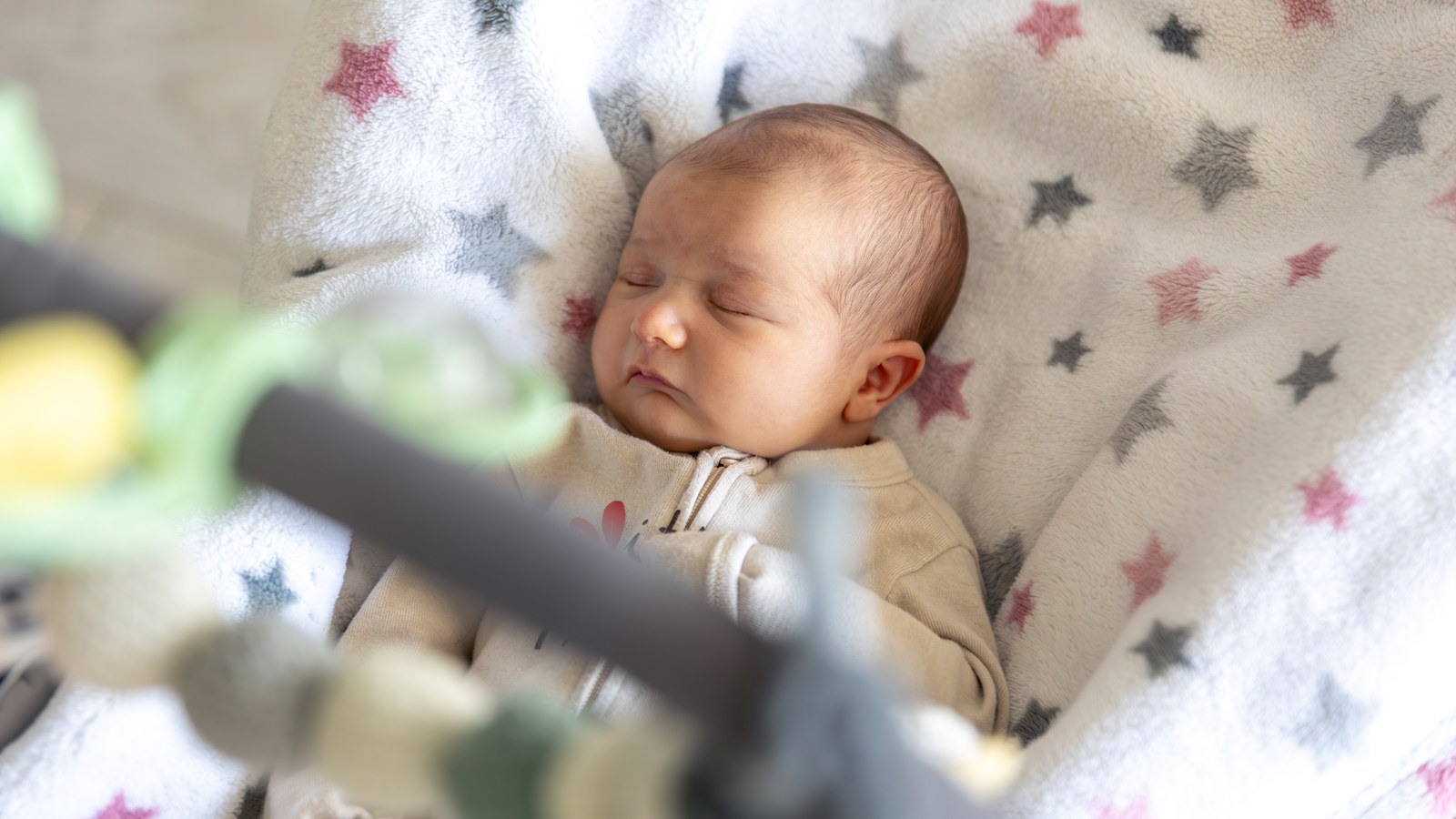 Newborn baby sleeping peacefully in child bed listening to soothing lullabies and music box chimes