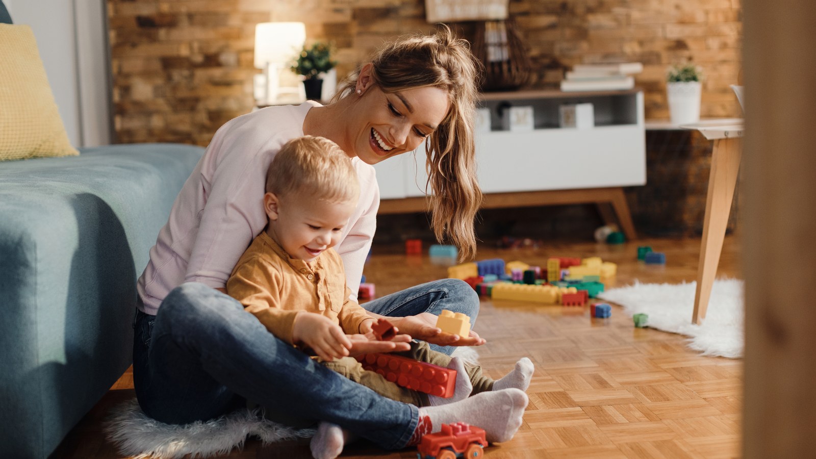 Professional domestic nanny playing with child in a safe, monitored living room
