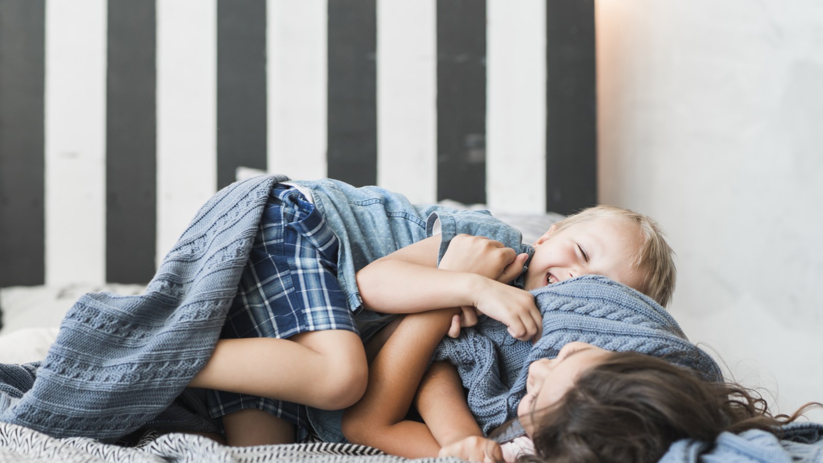 Due fratellini che dormono nella stessa cameretta con lettino e culla separati