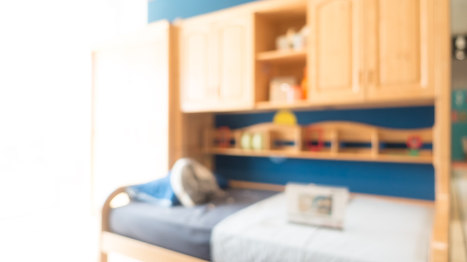 Cameretta per bambini accogliente e luminosa con lettino basso montessoriano e giochi in ordine