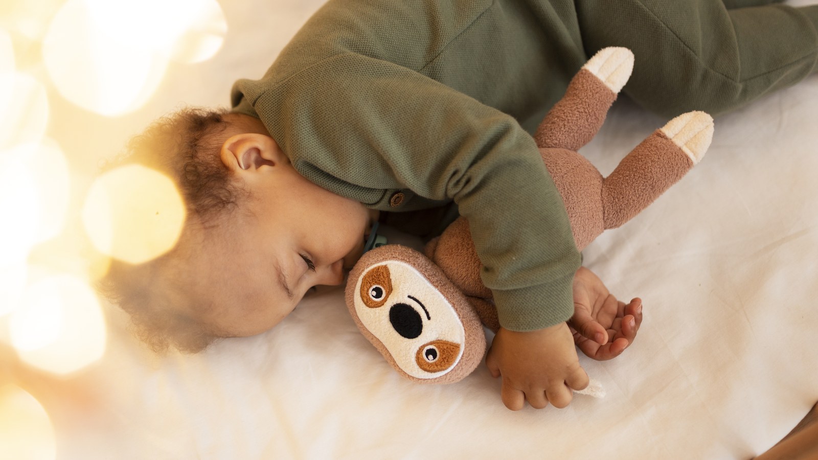 A newborn baby peacefully sleeping in a cozy nursery with soft ambient lighting and soothing acoustics.